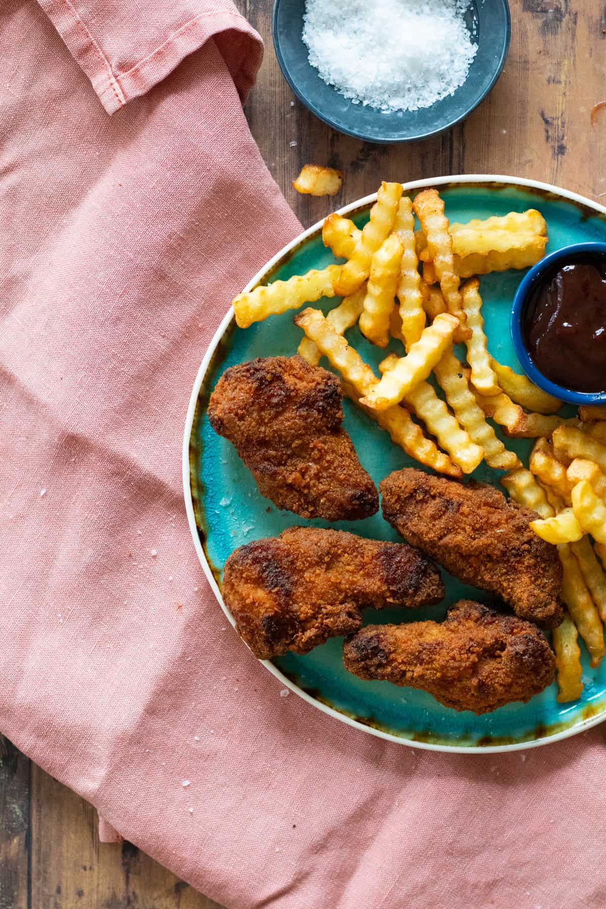 Fried chicken and fries on a blue plate.