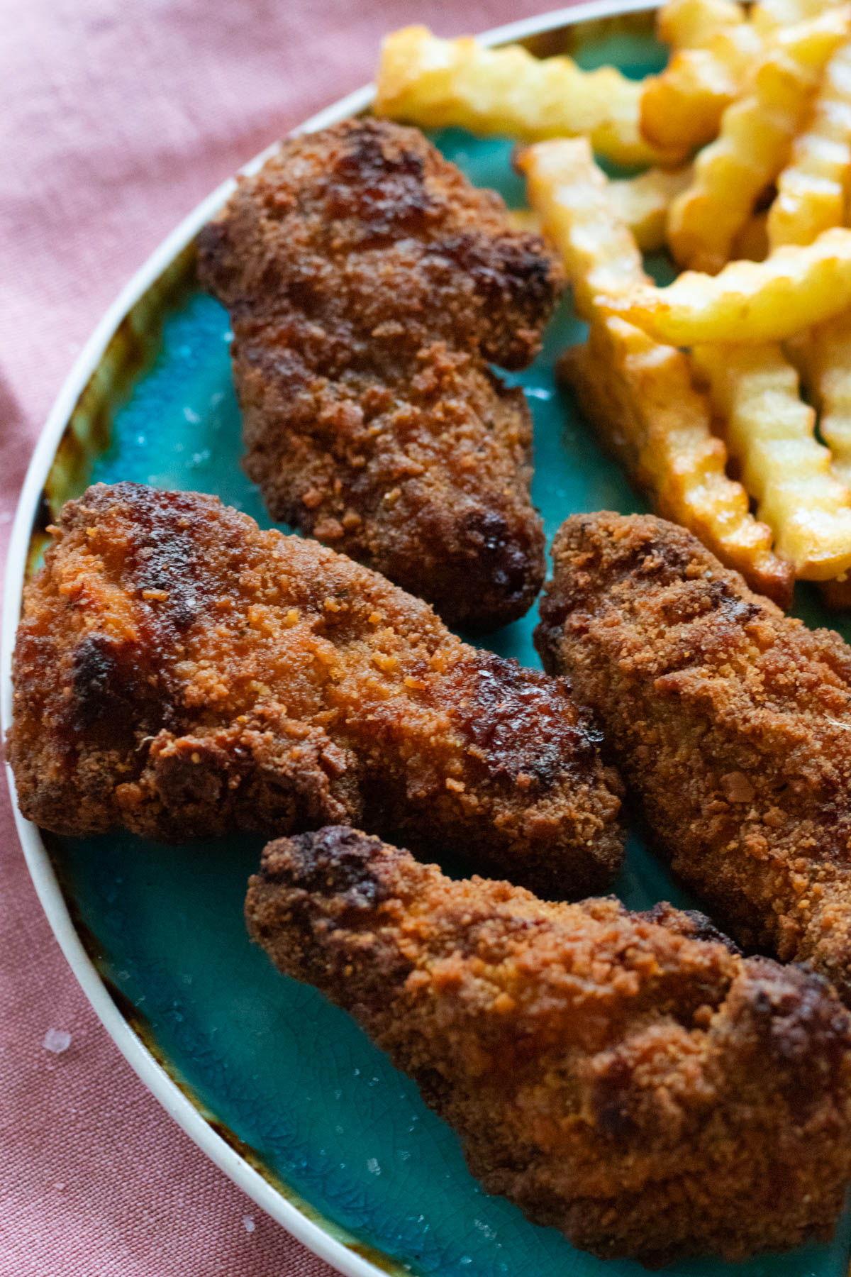 Fried chicken and fries on a blue plate.