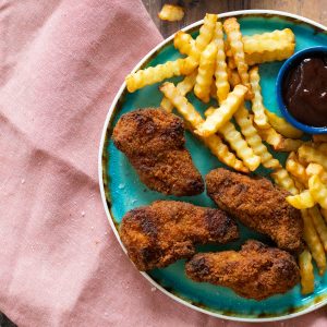 Fried chicken and fries on a blue plate.
