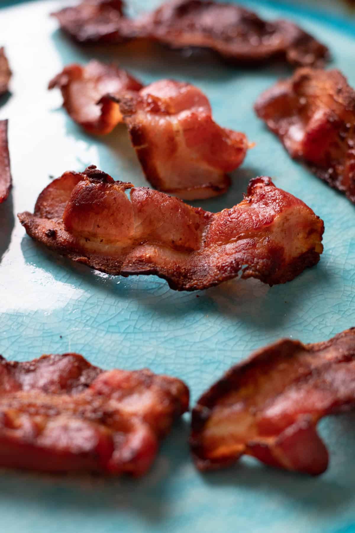 Air fried bacon on a blue plate.