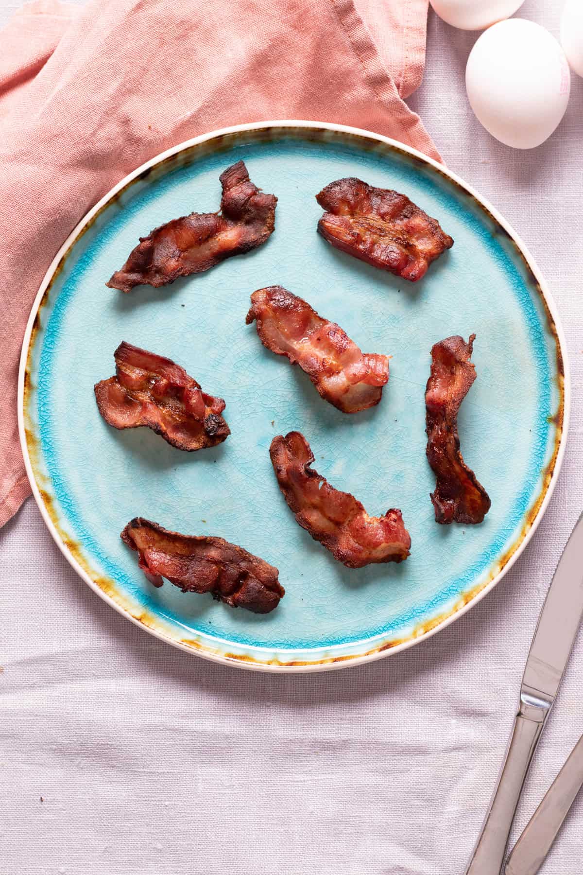 Air fried bacon on a blue plate.