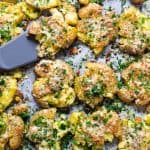 Smashed potatoes topped with parmesan and parsley.