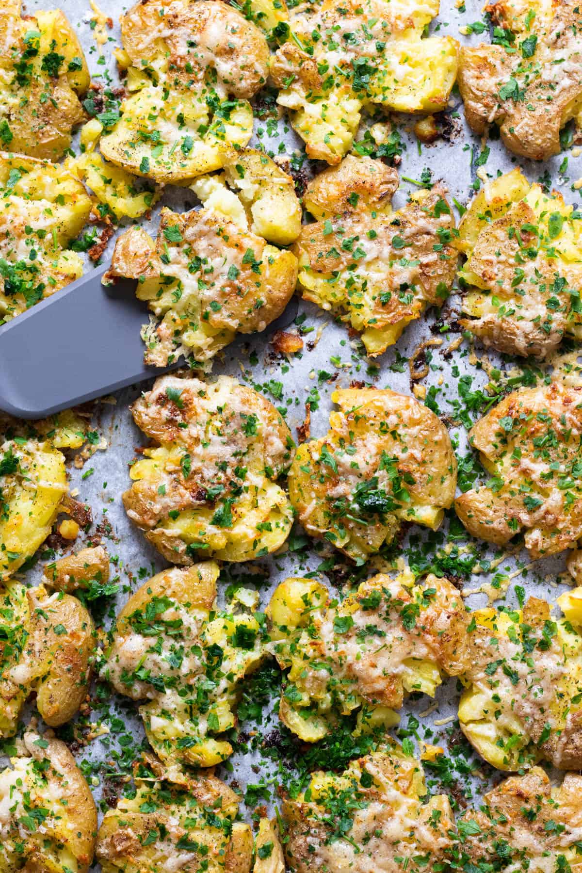 Smashed potatoes topped with parmesan and parsley.