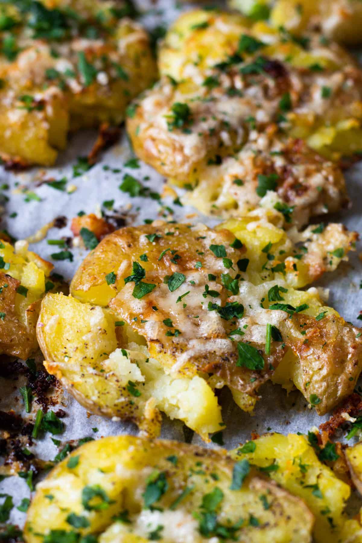 Smashed potatoes topped with parmesan and parsley.