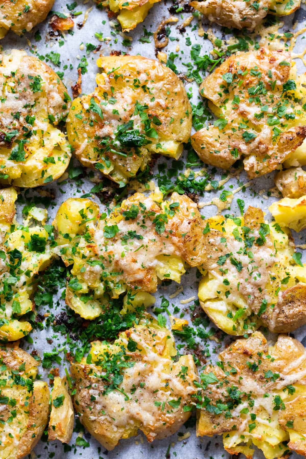 Smashed potatoes topped with parmesan and parsley.