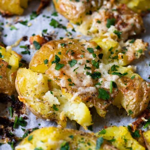 Smashed potatoes topped with parmesan and parsley.