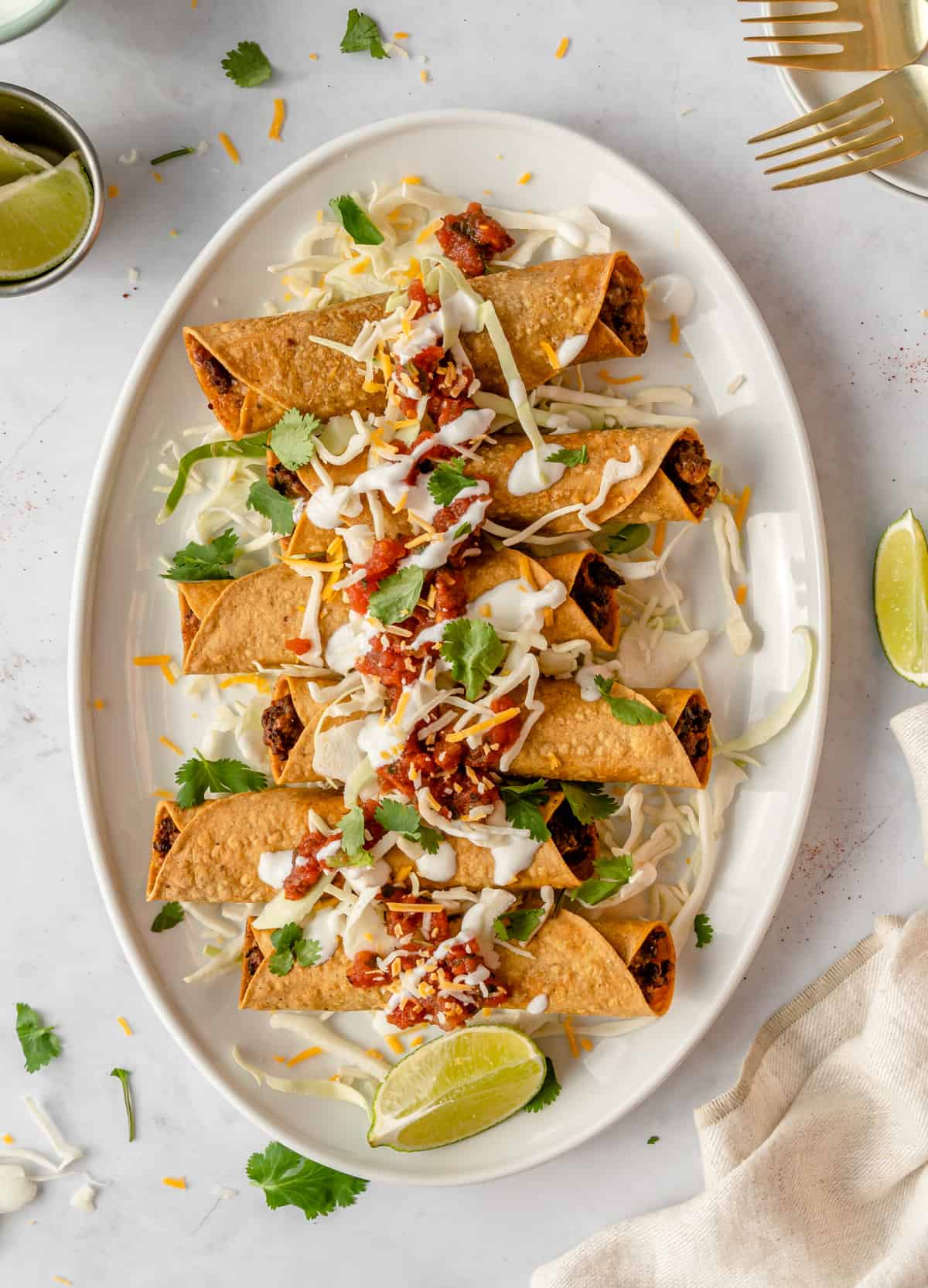 Air fryer taquitos on a white plate.