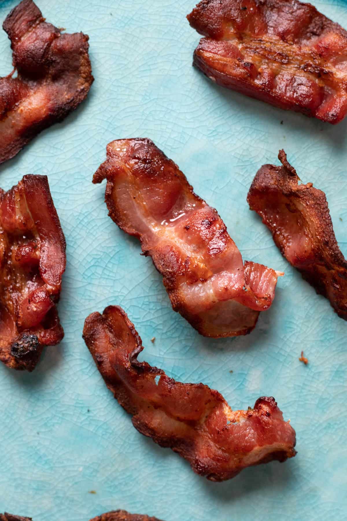 Crispy air fryer bacon on a blue plate.