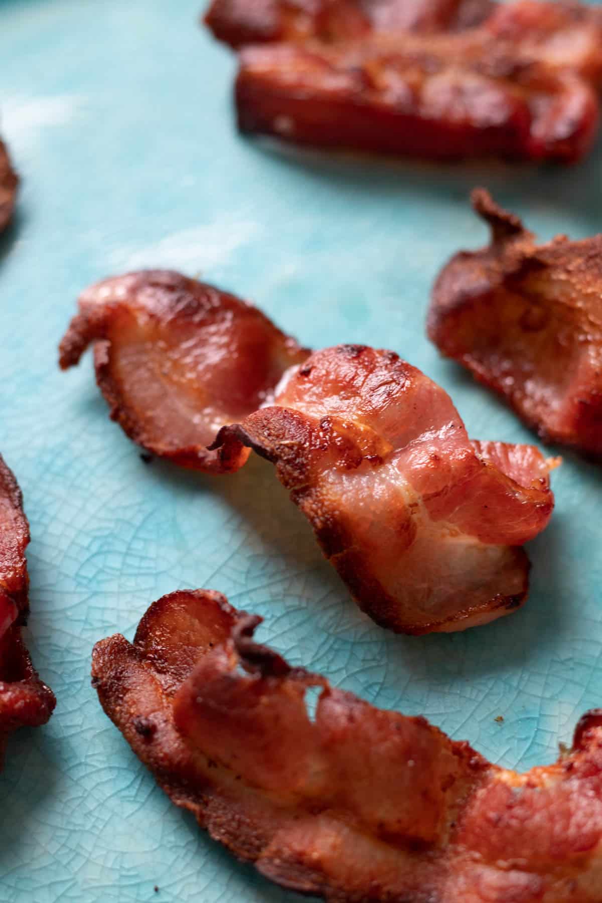 Crispy air fryer bacon on a blue plate.