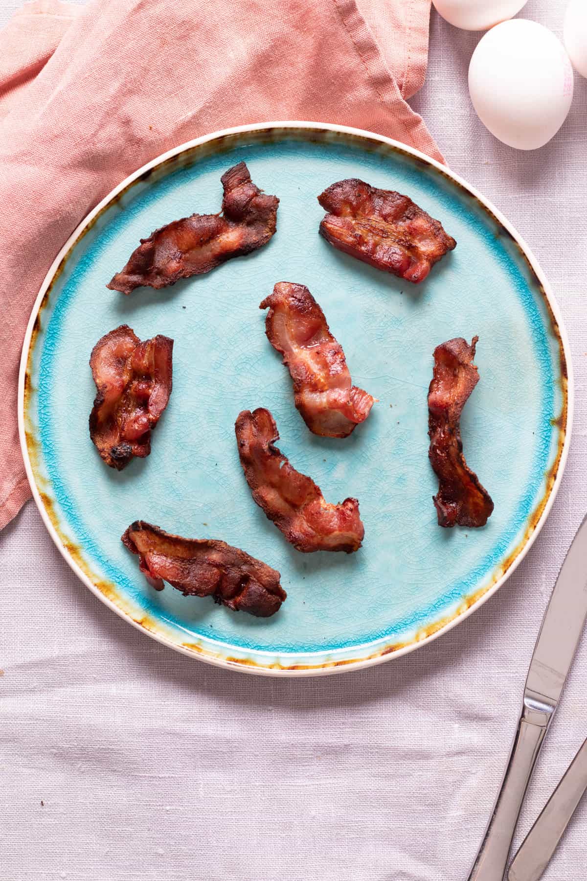 Crispy air fryer bacon on a blue plate.