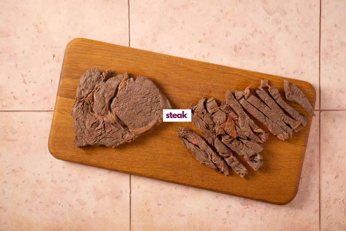 Cooked steak on a chopping board.