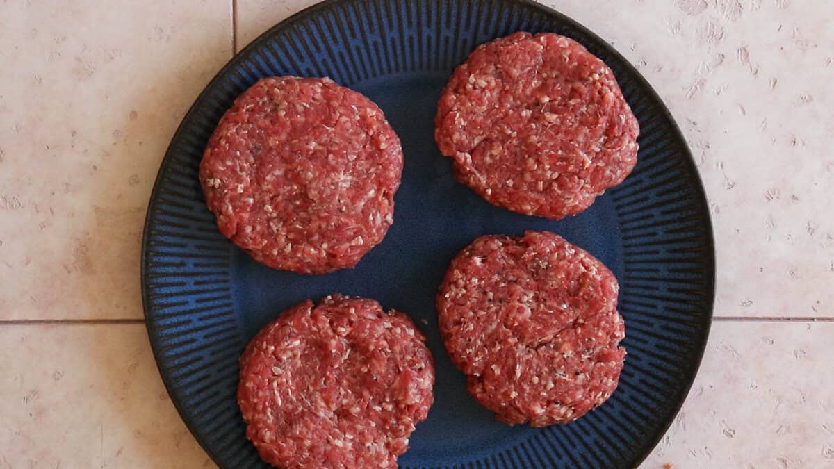 Four homemade hamburger patties before cooking.