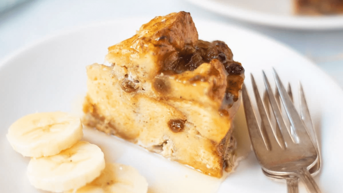 A piece of banan bread pudding on a plate.