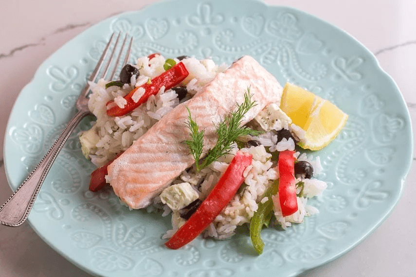 A plate of rice, salmon and veggies.