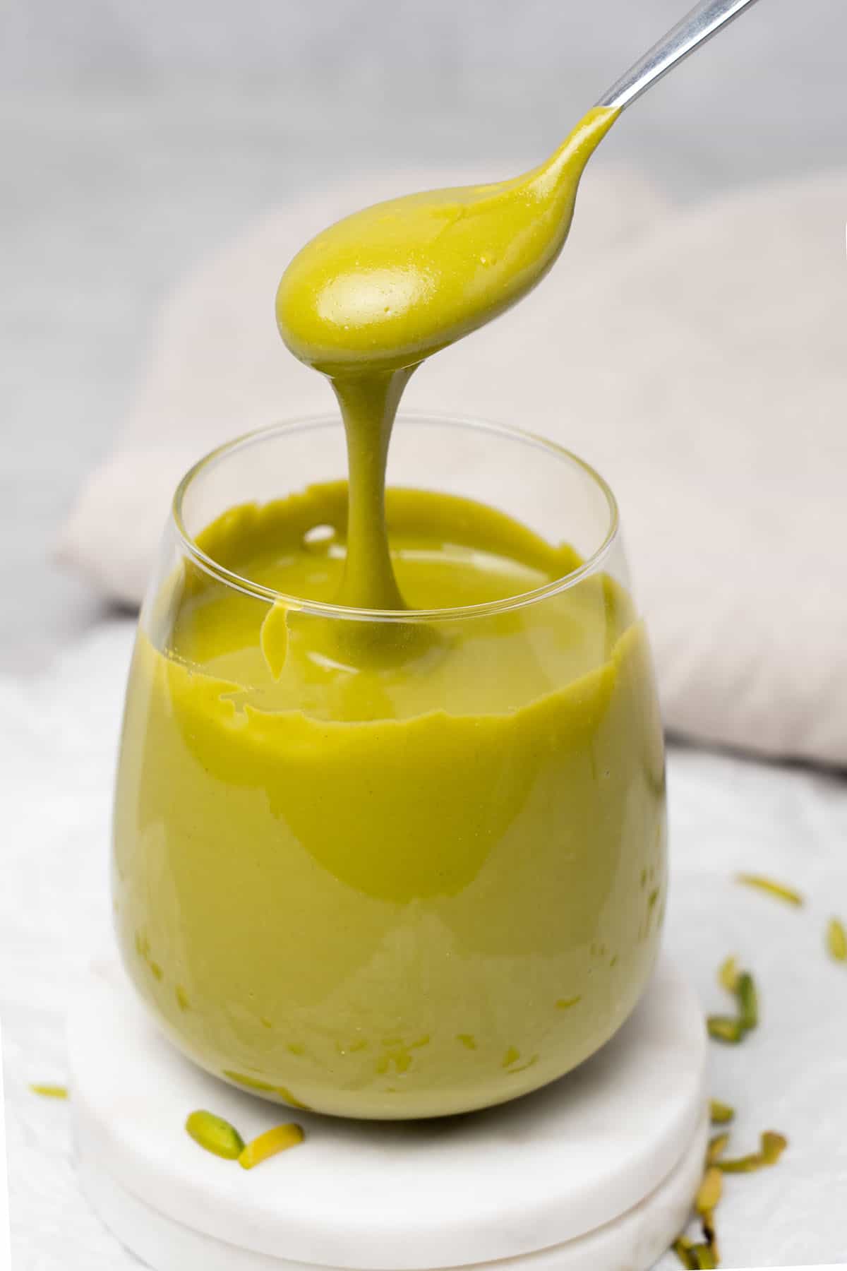A glass with pistachio butter.