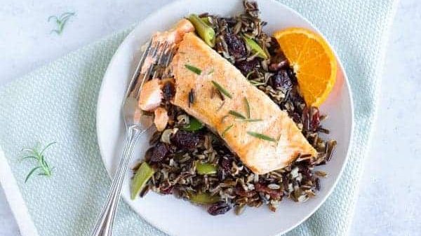 A bowl with salmon and black rice.