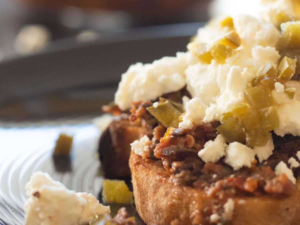 Sandwich topped with tapenade and Feta cheese.