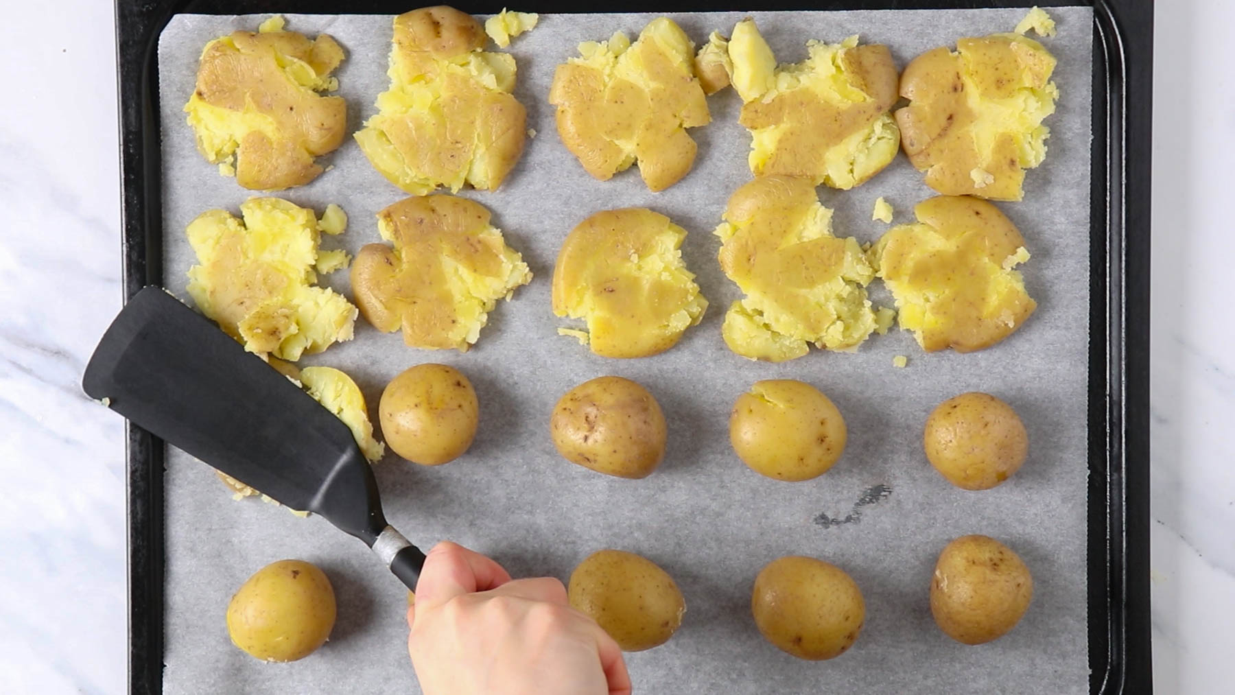 Smashing potatoes on a sheet pan.