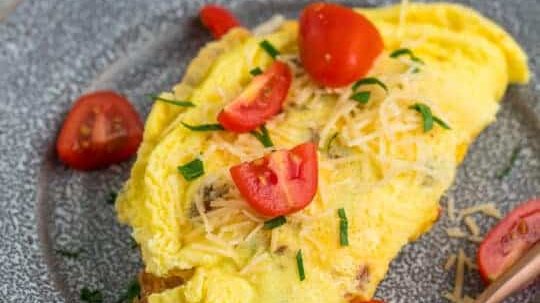 Air fryer omelette topped with tomatoes.