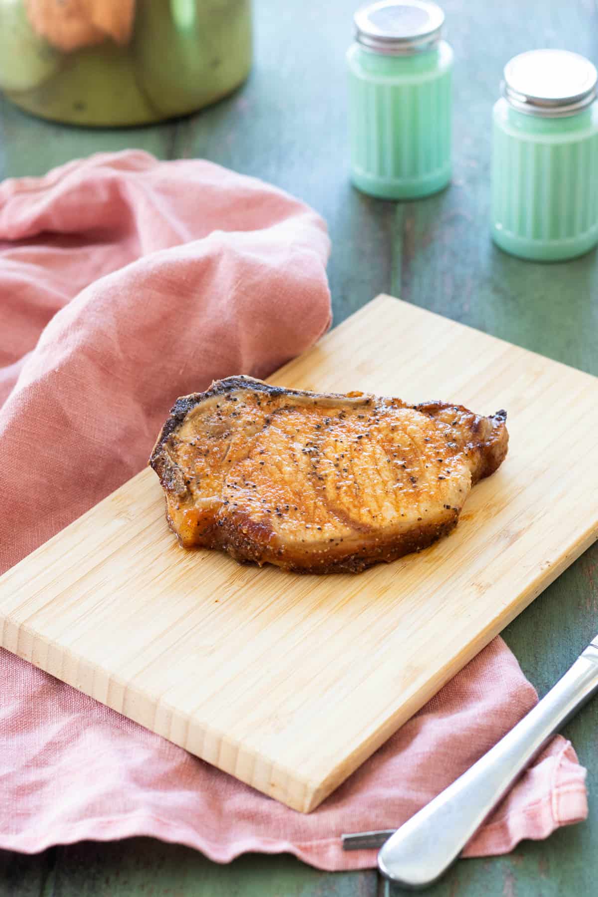 A pork chop on a small chopping board.