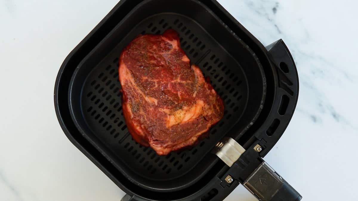A raw steak in air fryer.