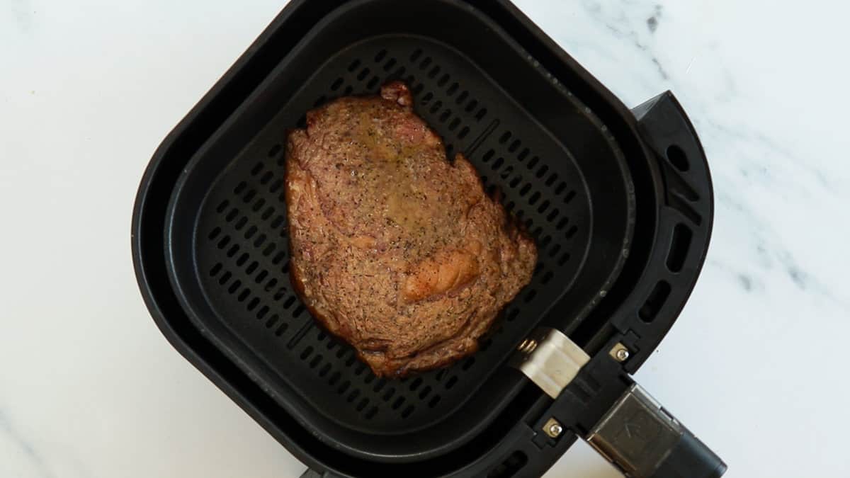 A cooked steak in air fryer.