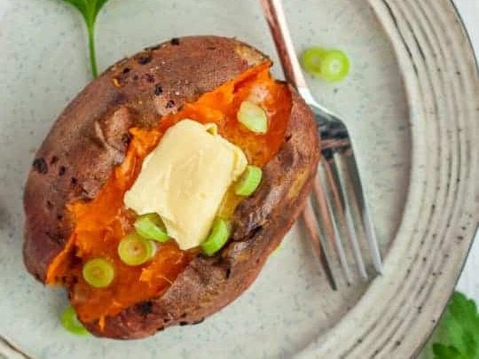 A baked sweet potato topped with butter.