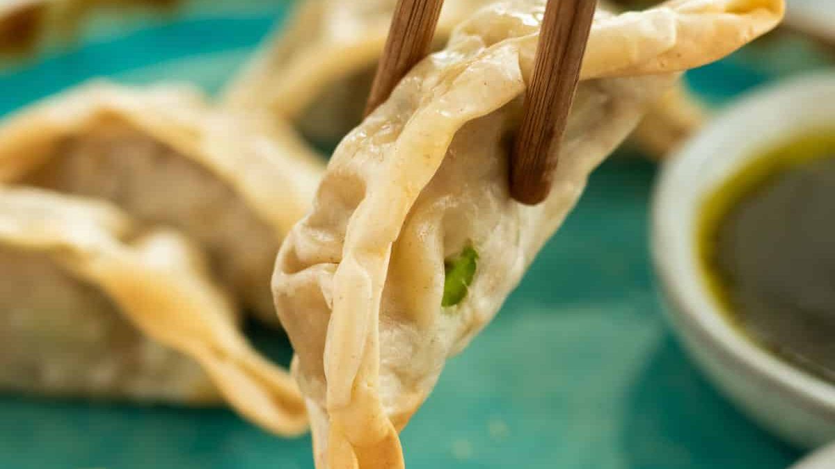 A dumpling picked up with chop sticks.