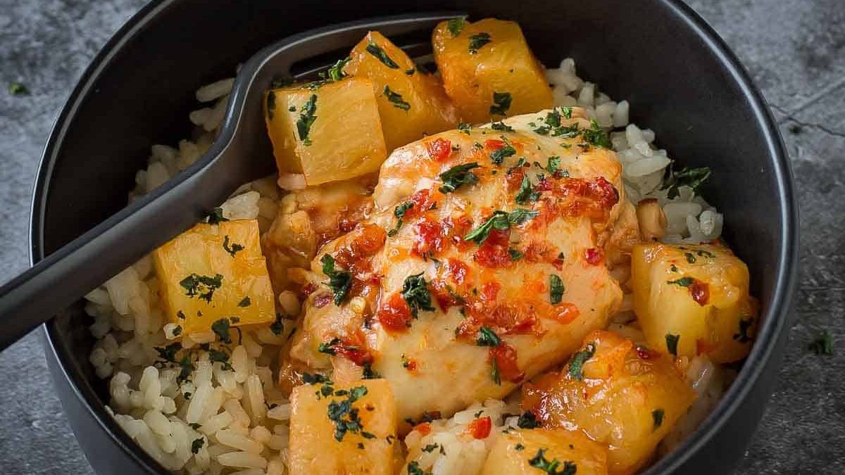 Chicken thighs and pineapple sauce in a bowl.