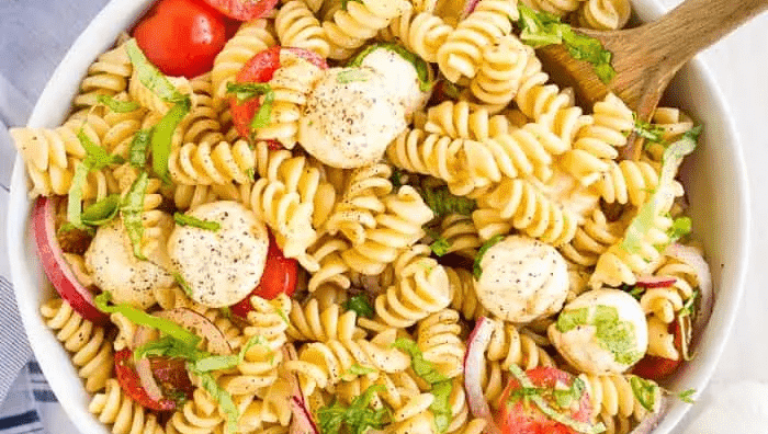 A bowl of caprese pasta salad.