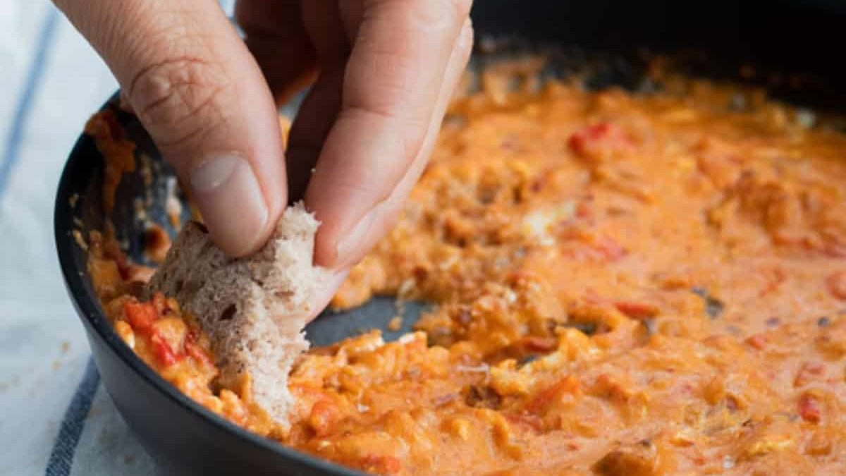 Dip being dipped in shakshuka.