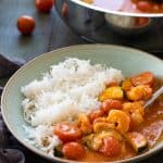 Shrimp curry on a plate with rice.