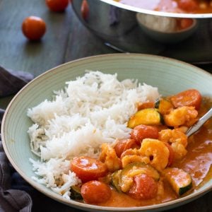 Shrimp curry on a plate with rice.