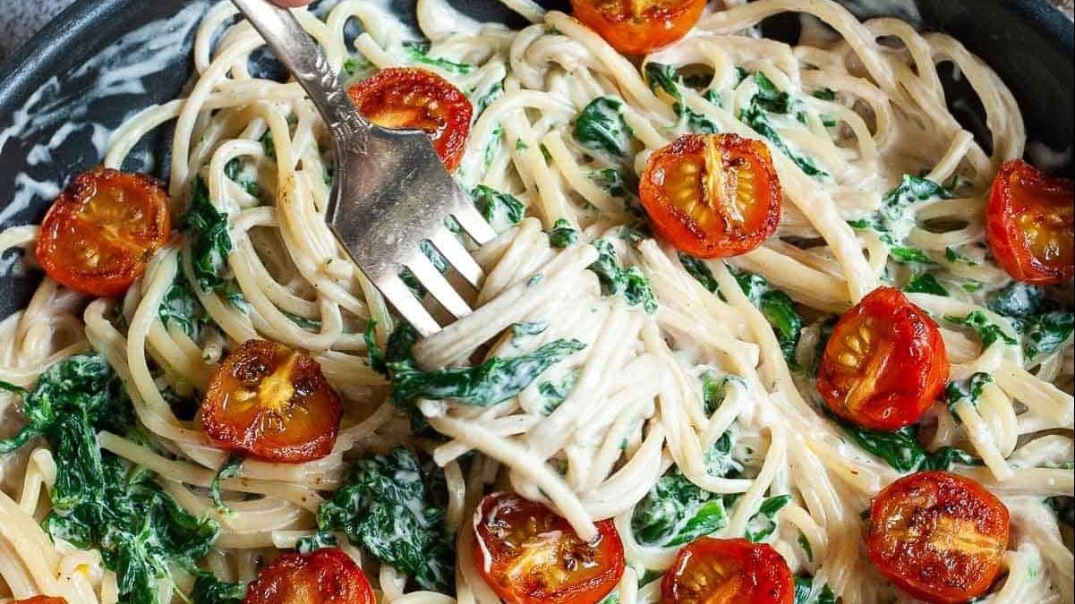 A skillet full of cashew alfredo pasta.