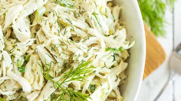 A bowl of chicken salad with dill.