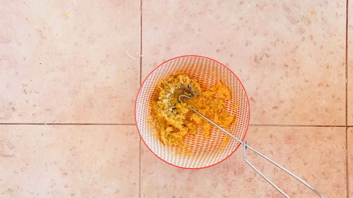 Cheese, egg yolks and black pepper mixed together in a bowl to prepare for a carbonara.