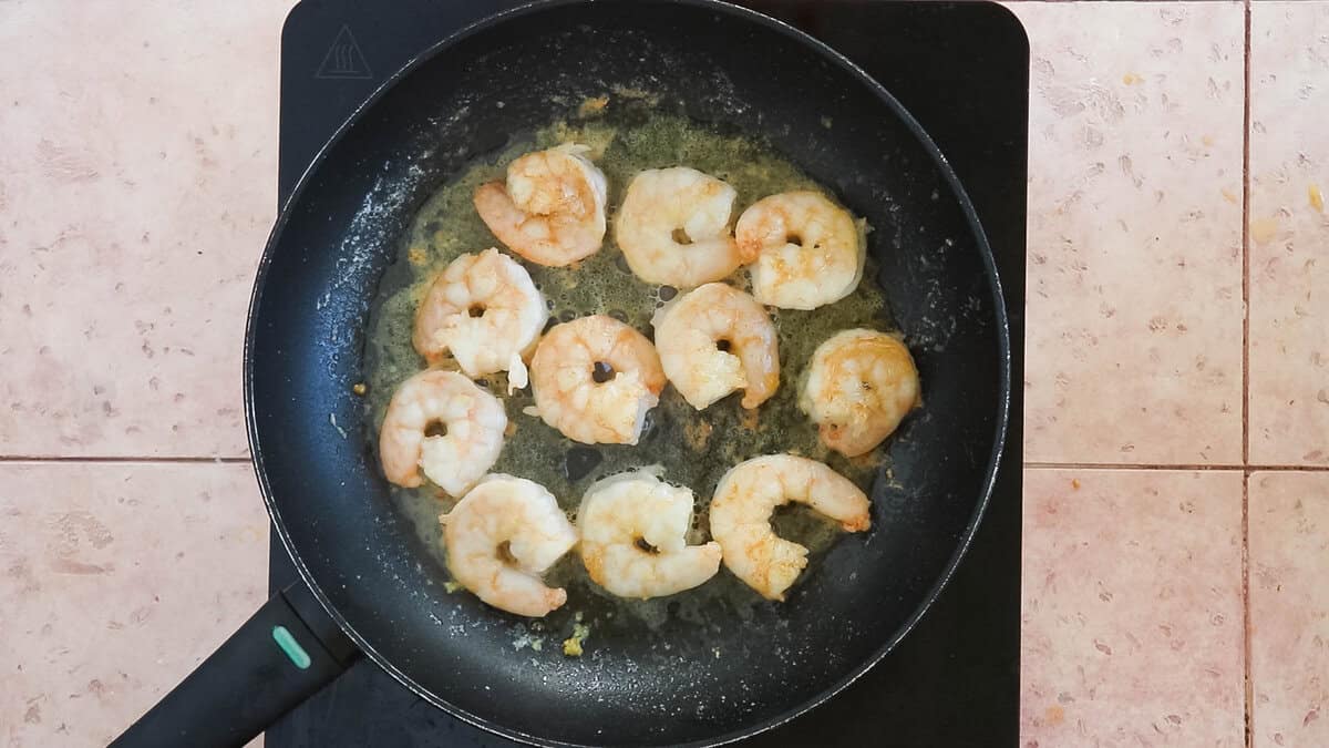 Pink shrimp in a pan that have been cooked to perfection.