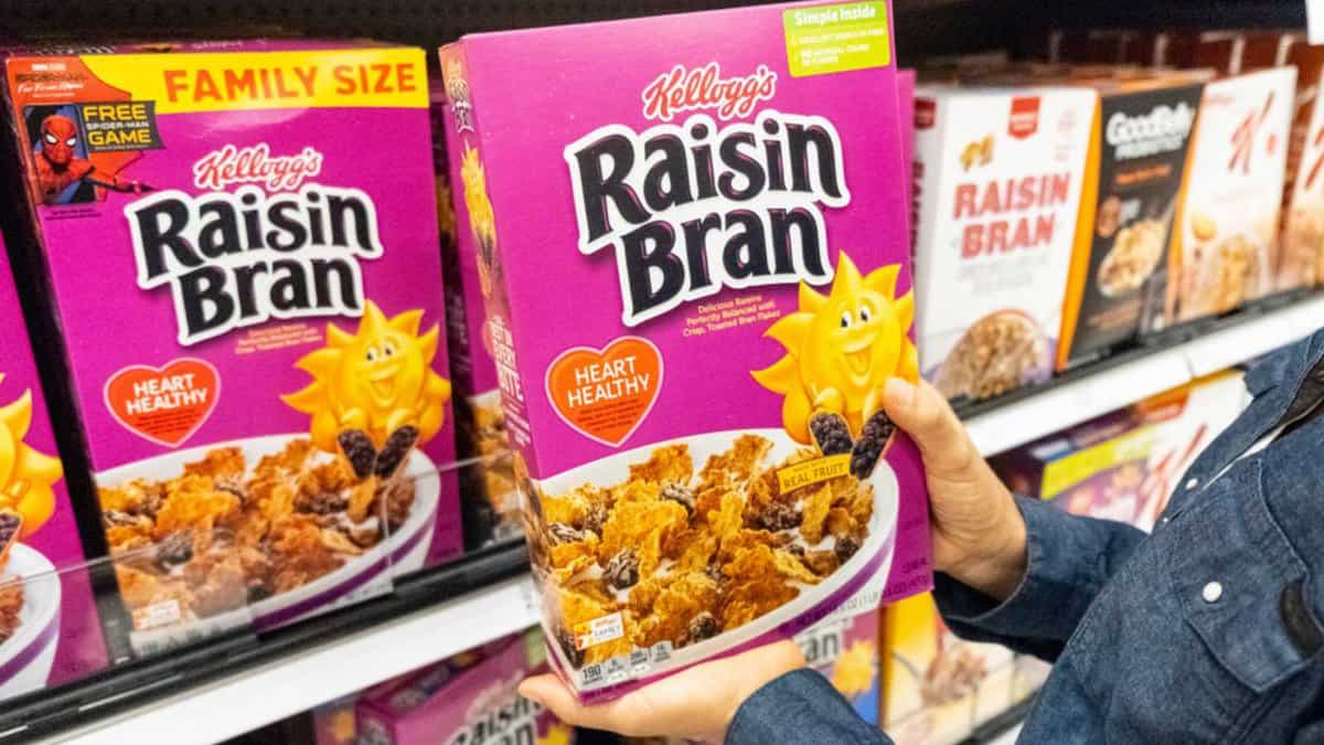 Los Angeles, CA/USA 08/21/2019 Shoppers hand holding a package Kellogg's Brand Raisin bran flakes cereal for sale in a supermarket aisle