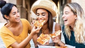 Woman eating New York City pizza