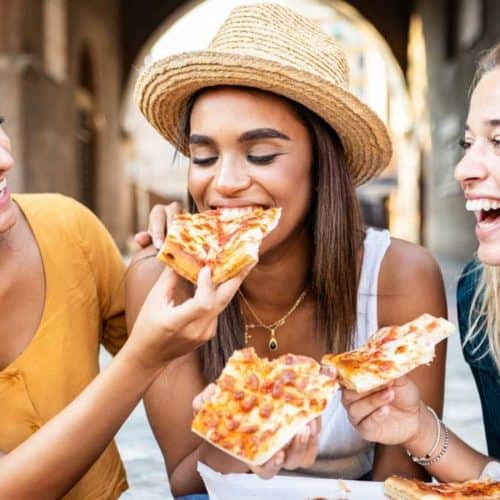 Woman eating New York City pizza
