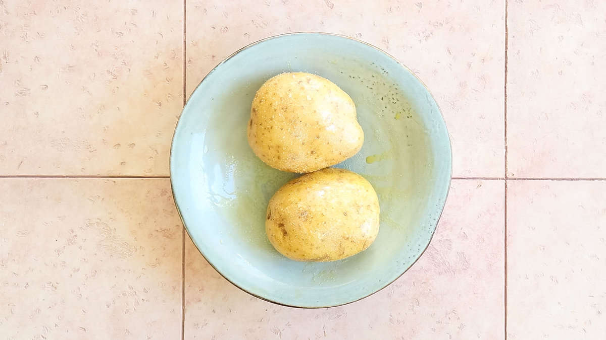 Baking potatoes covered in oil and salt.