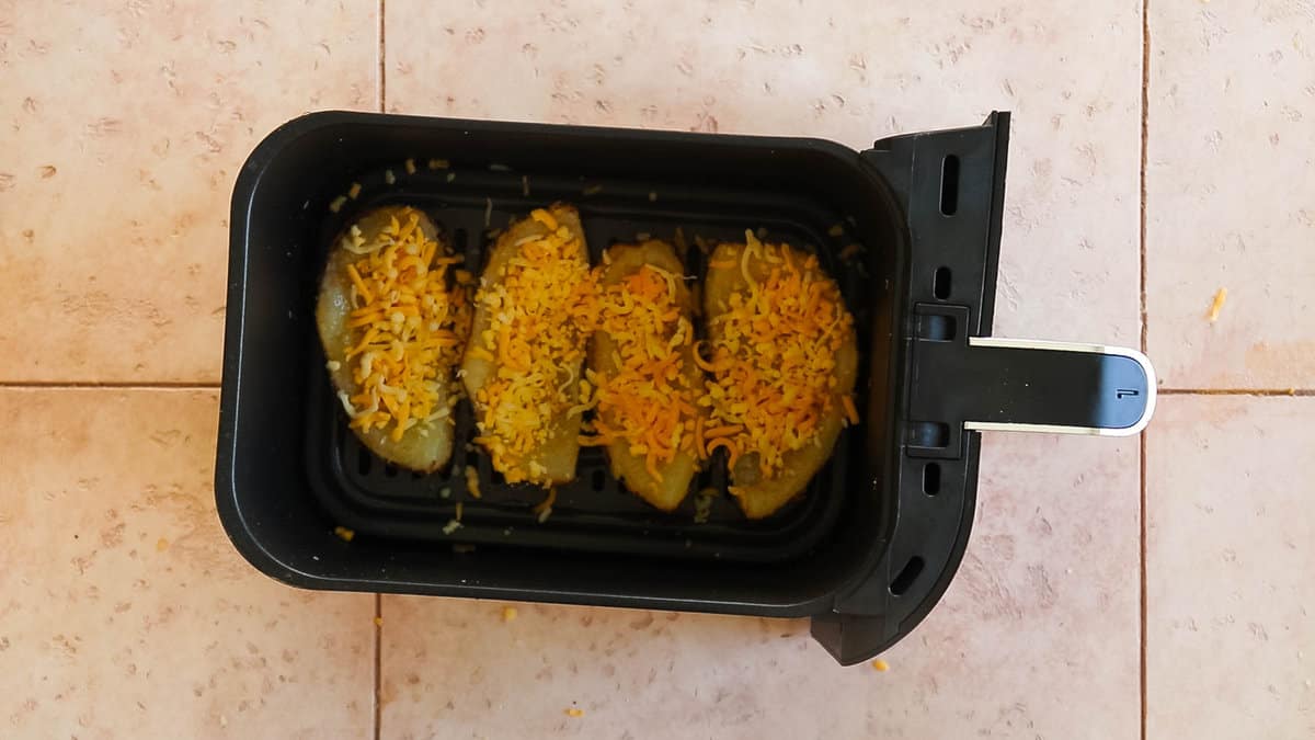 Potato skins in air fryer before cooking.