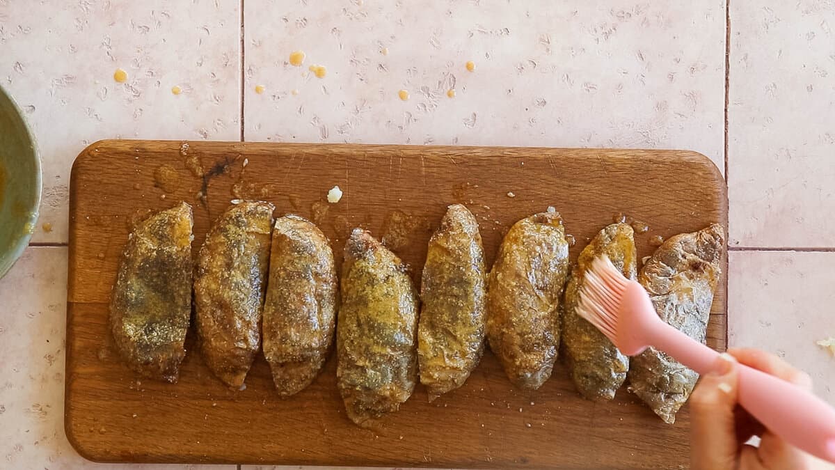 Brushing the outside of the potato skins with garlic butter.