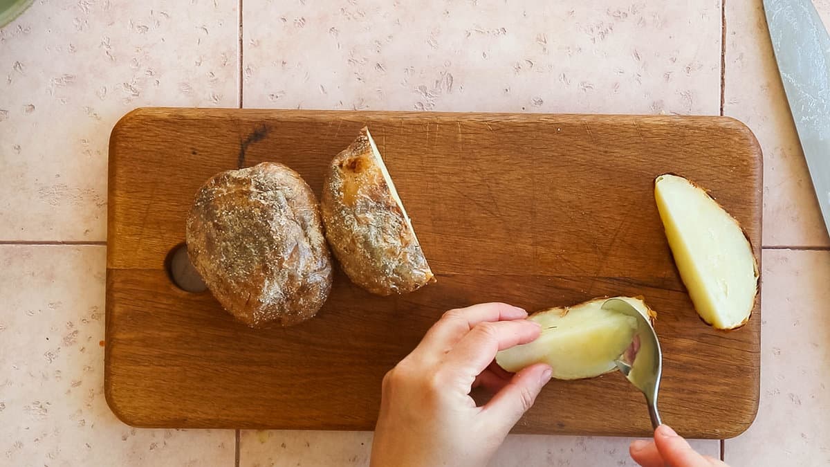 Scooping out potato from a potato skin.