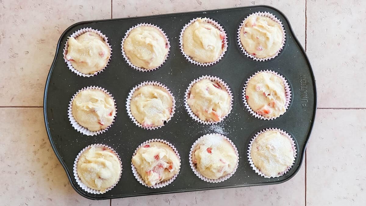 Strawberry muffins in a muffin tin before baking.