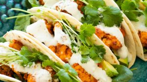 Buffalo cauliflower tacos topped with blue cheese sauce.