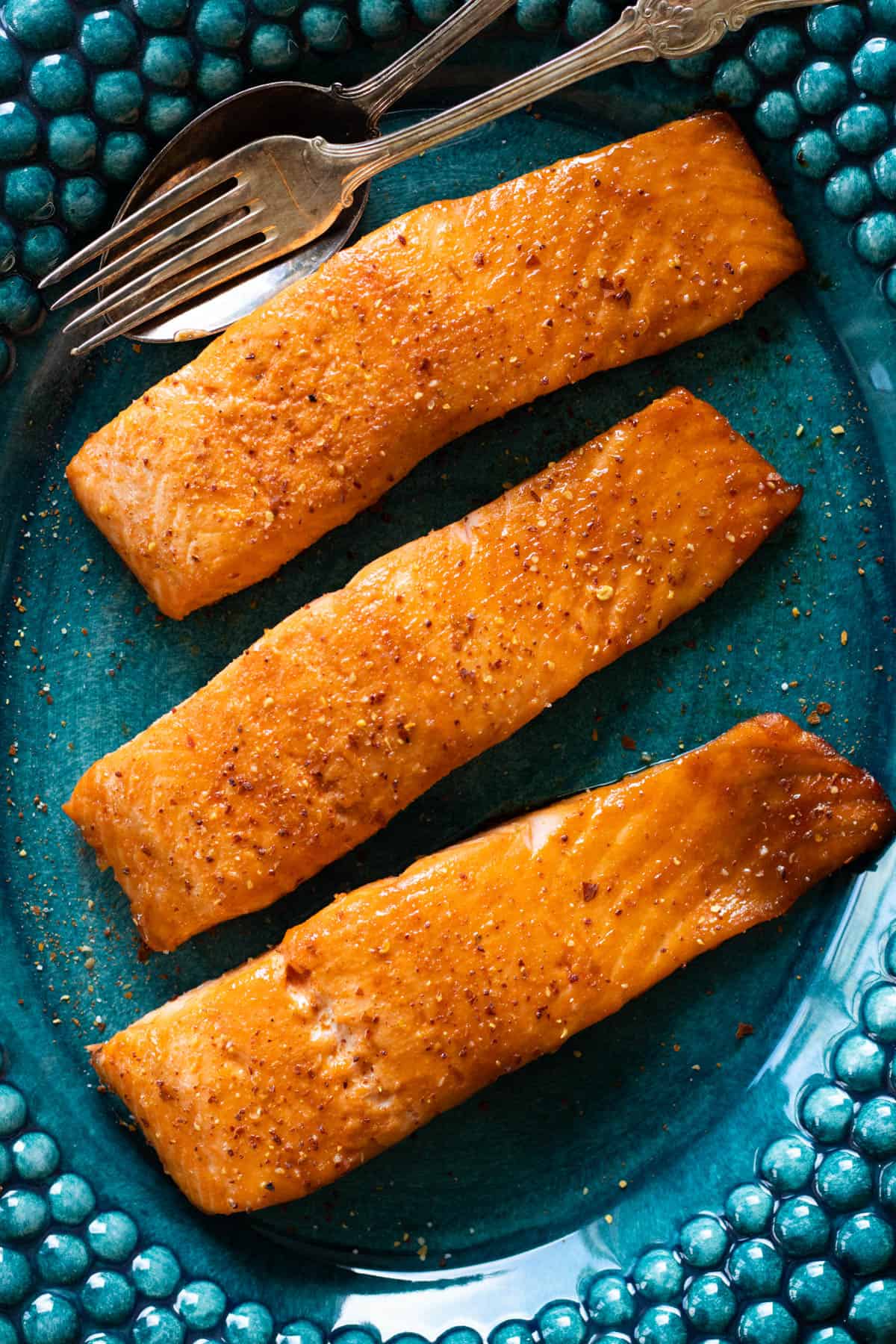 Firecracker salmon on a teal plate.