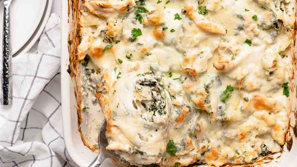 A casserole dish full of spinach artichoke casserole.