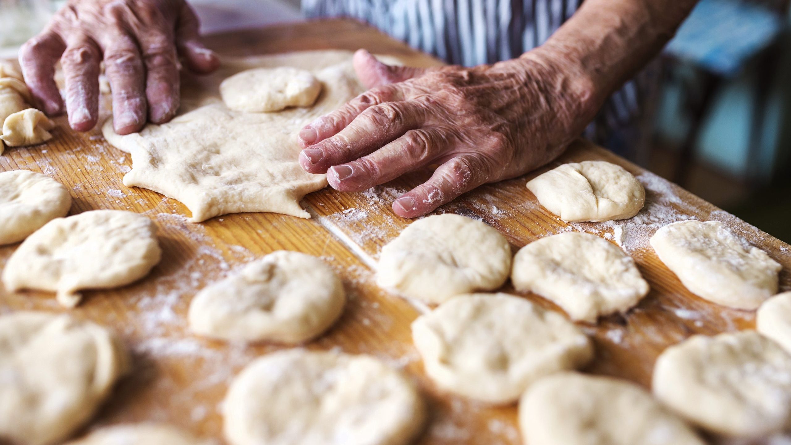 A woman forming dough.