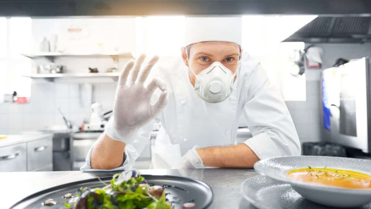 A chef with a mask serving food.